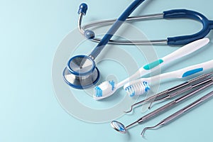 Dental care with dentist tools and toothbrush on blue background