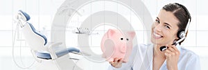 dental care savings and contact us concept, beautiful smiling woman with piggy bank and headset on dentist clinic background with