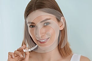 Dental care. Smiling woman using removable clear teeth braces