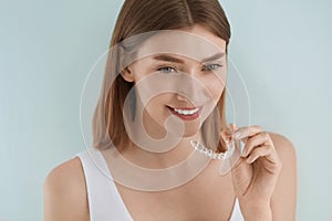 Dental care. Smiling woman using removable clear teeth braces photo