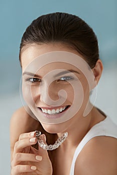 Dental care. Smiling woman with white smile using whitening tray