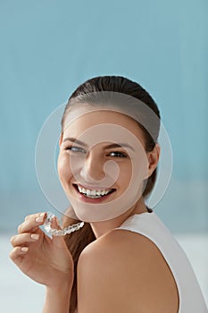 Dental care. Smiling woman with white smile using whitening tray