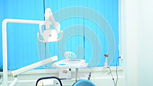 Dental chair and other accessories used by dentists in blue, medic light, medicine concept. Modern dental equipment in