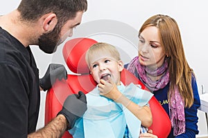 Dental clinic. Reception, examination of the patient. Teeth care. Dentist treating teeth of little boy in dentist office