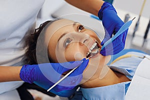 Dental doctor in latex gloves treating woman teeth