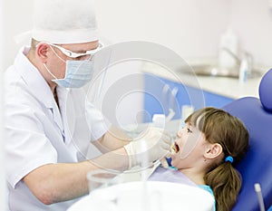 Dental examining being given to girl by dentist photo