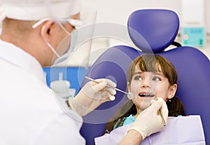 Dental examining being given to little girl by dentist