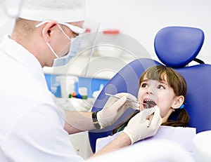 Dental examining being given to little girl by den photo