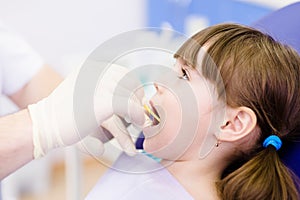 Dental examining being given to little girl by den photo