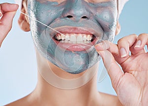 Dental, face mask and woman flossing her teeth for healthy and strong teeth in a studio portrait with a blue background
