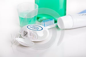 Dental floss focused with toothbrush, toothpaste, mouthwash, at