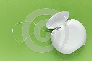 Dental floss on a green background with copy space, top view