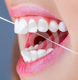 Dental floss. Oral hygiene and health care. Smiling women use dental floss white healthy teeth. Dental flush - woman