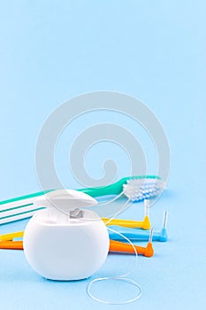 Dental floss, toothbrush and interdental brush angles on blue background, vertical, copy space