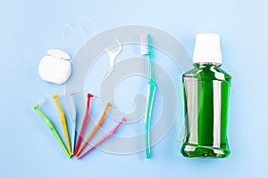 Dental floss, toothbrush, interdental brush angles and mouthwash on blue