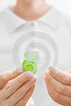 Dental floss in woman hands close up