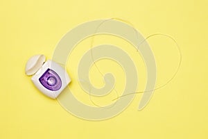 Dental floss on a yellow background