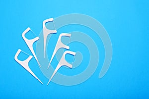 Dental flossers on light blue background, flat lay. Space for text
