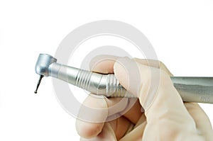 Dental handpiece in the hands of the dentist isolated on white background close-up, dental drill