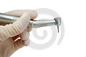 Dental handpiece in the hands of the dentist isolated on white background close-up, dental drill