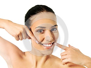 Dental health concept - beautiful woman pointing to her teeth