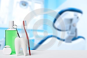 Dental health and teethcare concept. Dental mirror in white tooth model near mouthwash, toothbrush and dental floss against dental