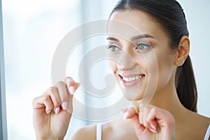 Dental Health. Woman With Beautiful Smile Flossing Healthy Teeth