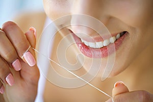 Dental Health. Woman With Beautiful Smile Flossing Healthy Teeth