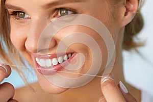 Dental Health. Woman With Beautiful Smile Flossing Healthy Teeth