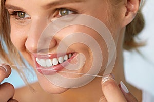 Dental Health. Woman With Beautiful Smile Flossing Healthy Teeth photo