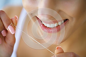 Dental Health. Woman With Beautiful Smile Flossing Healthy Teeth