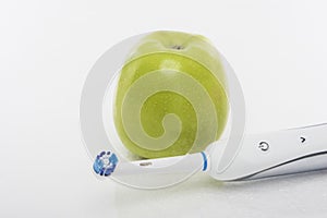 Dental Hygien Concept: Green apple Together With Electric Toothbrush photo