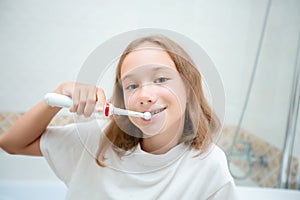 Dental hygiene. Happy little blonde girl brushing her teeth. Healthy concept