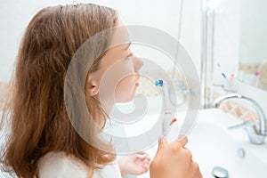 Dental hygiene. Happy little blonde girl brushing her teeth. Healthy concept