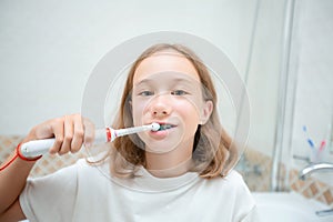 Dental hygiene. Happy little blonde girl brushing her teeth. Healthy concept