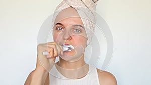 Dental hygiene. Oral care. Beautiful young woman in towel on head holding toothbrush brushing teeth cleaning mouth doing morning