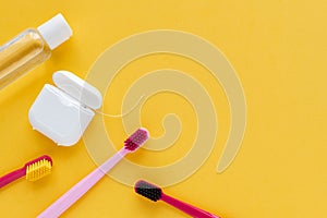 Dental hygiene - tooth brushes, dental floss, mouthwash flat lay, top view, copy space, yellow background