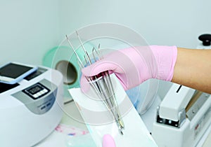 Dental instrument packaging in a sterilization bag.A medical worker puts a medical instrument in a device for disinfection and