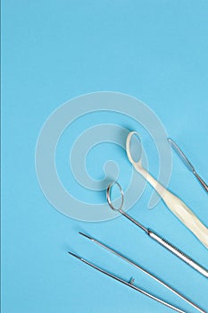 Dental instruments on a blue background. Vertical photo.