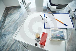 Dental instruments and clipboard are left on table
