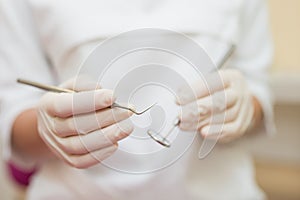 Dental instruments in the hands of the doctor. Dentist in sterile latex gloves holding dental tools detail shoot