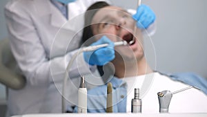 Dental instruments and patient at dental clinic