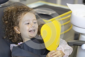 Dental kid. examination treatment teeth children. medical  checkup oral cavity. child looking at cured teeth in mirror. Happy girl