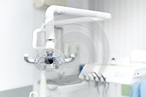 Dental light stand next to dental chair and tools