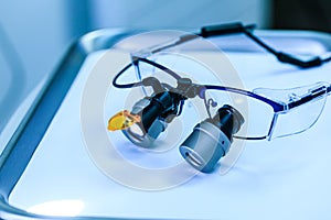 Dental medical glasses with binocular lenses, in dentistry clinic. Dentist glasses or dental optic on a real medical laboratory.