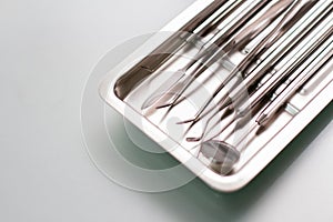 Dental medical tools in metal tray on glass table