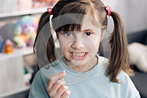 Dental medicine or temporary teeth health care concept. Portrait of a baby girl with a toothless smile. Shows a ripped