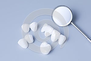 Dental mirror and dentures on a light blue background