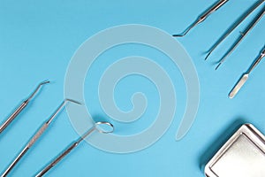 Dental mirrors and probes on a blue background.