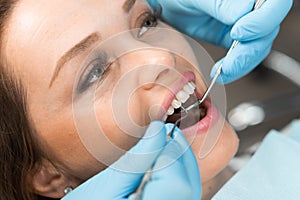 In the dental office, the doctor confidently works with modern equipment and tools, providing the patient with